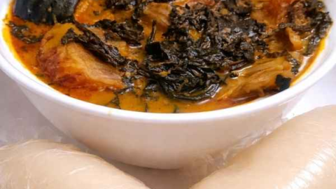 Freshly prepared Ofe Onugbu bitter leaf soup served with fufu swallow on a dinner table, showing a traditional Nigerian meal ready to eat