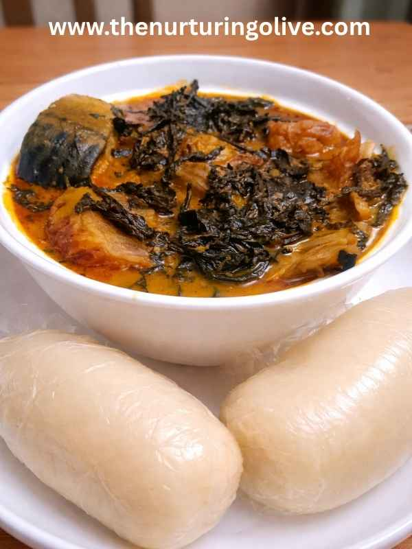 Freshly prepared Ofe Onugbu bitter leaf soup served with fufu swallow on a dinner table, showing a traditional Nigerian meal ready to eat
