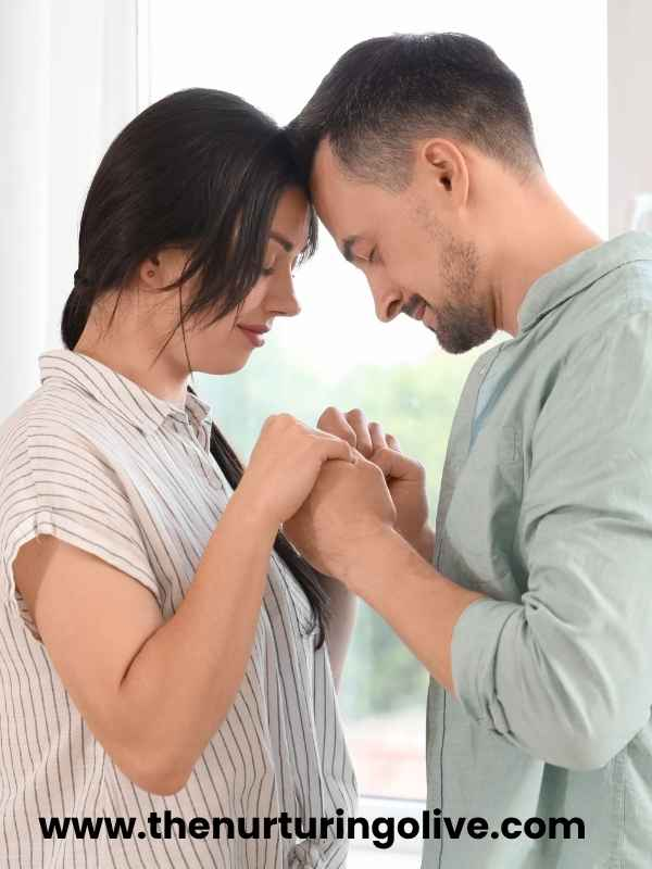 Christian couple learning how to pray with their partner while holding hands during morning prayer